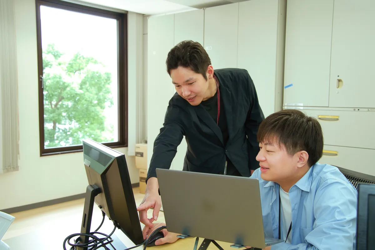 パソコンの画面を一緒に確認する社員